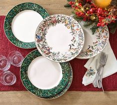 a table set for christmas with plates and silverware