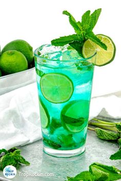 a green drink with limes and mint on the side