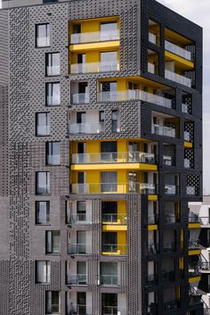 a tall building with yellow balconies and windows