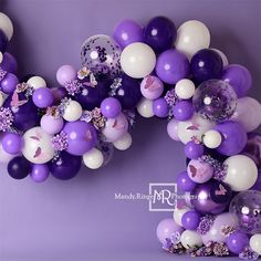 purple and white balloons are arranged in the shape of the letter o on a purple background