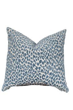 a blue and white leopard print pillow on a white background