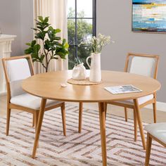 a dining room table with chairs and a potted plant on top of the table