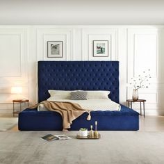 a blue bed sitting in the middle of a bedroom next to a white wall and floor