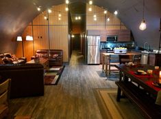 a living room filled with furniture next to a kitchen and dining area in a loft