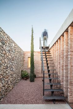 the stairs lead up to the top floor of this modern house, which is made out of bricks