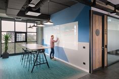 a man standing next to a whiteboard in an office