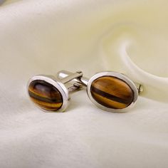 Weight: 9.91 grams Cufflinks width: 13 MM Cufflinks Length: 16 MM Materials ~ Natural Tiger Eye Gemstone ~ 925 Sterling Silver ~ Exclusive Designer Jewellery GROOMSMEN GIFTS: A memorable and classy gift for your Groomsmen which they'll be able to wear to other occasions as well. These Cufflinks have a rich and elegant look which gives your men more attractive look in very reasonable price. Healing Properties of Tiger Eye By activating and balancing the third chakra, the solar plexus, Tiger's Eye Oval Polished Cufflinks For Business, Classic Oval Silver Cufflinks, Elegant Oval Cufflinks For Business, Oval Polished Finish Cufflinks For Gift, Silver Oval Cufflinks For Gift, Oval Polished Cufflinks For Gift, Silver Oval Cufflinks Gift, Oval Cufflinks For Business, Silver Oval Cufflinks As Gift