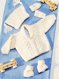 a knitted sweater and other items laid out on a blue towel