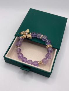 Size: 5.5-7.0inch 11mm This bracelet features natural amethyst beads, approximately 11cm, adorned with a gold-plated cubic zirconia butterfly. The design inspiration comes from the graceful elements of nature, evoking the light purple of lavender and the delicate flight of butterflies. This piece combines the mysterious allure of natural amethyst with the splendid elegance of gold-plated cubic zirconia, showcasing a blend of natural beauty, peace, and grace. Gold Charm Bracelet With Natural Stones Gift, Elegant Purple Bracelets As Gift, Gold Plated Bracelets With Natural Stones For Gift, Elegant Purple Bracelets For Gifts, Gold Crystal Bracelet With Gemstone Beads As Gift, Luxury Gold Plated Beaded Bracelets As Gift, Gold Crystal Bracelet With 8mm Beads As A Gift, Elegant Purple Beaded Bracelet For Gift, Amethyst Gemstone Beads Bracelet As Gift