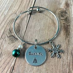 a silver bracelet with a snowflake charm and personalized charms on the side