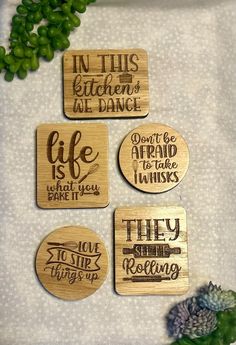 four wooden coasters with words on them