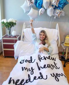 a woman is laying in bed with balloons and writing on the sheet that says god knew my heart needed you