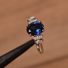 It is a lab sapphire ring. The main stone is 7 mm*9 mm oval cut.weight about 2.32 carats.The basic metal is sterling silver and plated with rhodium.To change the metal to a solid gold (white/rose) or platinum is also available, please ask for a quotation if you want.You can also go to my shop Home for more elegant rings: https://www.etsy.com/shop/godjewelry?ref=hdr_shop_menu Sapphire is September birthstone.More sapphire rings:https://www.etsy.com/shop/godjewelry?section_id=20715031Customization Classic Silver Sapphire Ring, Classic Silver Sapphire Ring With Lab-created Sapphire, Classic Silver Birthstone Ring With Lab-created Sapphire, Silver Oval Sapphire Ring, Silver Oval Sapphire Birthstone Ring, Oval Sapphire Birthstone Ring In Cubic Zirconia, Silver Birthstone Ring With Lab-created Sapphire And Accent Stones, Oval Lab-created Sapphire Birthstone Ring, Silver Lab-created Sapphire Ring In Fine Jewelry Style