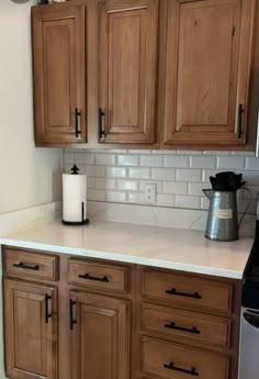 a kitchen with wooden cabinets and white counter tops