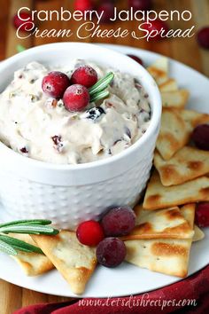 cranberry jalapeno cream cheese spread in a white bowl surrounded by crackers