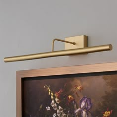 a painting hanging on the wall next to a light fixture with flowers painted on it