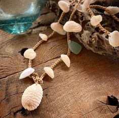 These Hawaiian ark shells look like tiny angel wings. They have been gathered from Hawaii's longest white sand beach which is known as Papohaku. This beach has a dangerous shore break that leaves these shells embedded with sand. It is also very windy most of the time so the shells usually get blown back into the ocean. Conditions must be perfect for me to find these gems.  They have been carefully drilled and crocheted with nylon cord for strength. I have added some seafoam seaglass and a bumpy cowrie for the closure. You can wear this wrap 4 times around your wrist, three times around your ankle or once or twice around your neck. When wearing as a bracelet simply wrap it around, pull the anchor shell thru the hoop, pull tight and tuck the anchor shell under one of the strands.  This one m Bohemian Adjustable Sea Glass Necklaces, Adjustable Shell Coastal Jewelry, Adjustable Coastal Shell Jewelry, Adjustable Shell Shaped Coastal Jewelry, White Adjustable Shell Necklace Spiritual Style, White Adjustable Shell Necklace For Spiritual Wear, White Adjustable Spiritual Shell Necklace, Handmade Spiritual Shell For Beach, Handmade Spiritual Beach Shell