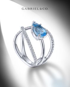 A pear shaped swiss blue topaz stone is suspended between the split shank band of this architectural ring, radiating a serene blue hue. Much of the gracefully arched shank is garnished with 0.35cts of pavé diamonds. LR51561W45BT #GabrielNY#DiamondJewelry#FineJewelry#GabrielAndCo#UniqueJewelry#FineJewelry#FashionJewelry#UniqueJewelry#GiftIdeas#UniqueGifts#DiamondJewelry#Jewelry#WhiteGoldRing#Rings#FashionRings#Ladies'Ring#BlueTopazRing Boho Jewelry Diy Bohemian, Architectural Rings, Diy Bohemian, Ladies Rings, Swiss Blue Topaz Ring, Wedding Ring Necklaces, Blue Topaz Stone, Ladies Ring, Gemstones Jewelry