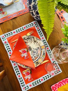 the table is set with plates, napkins and flowers