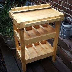 a wooden workbench sitting on top of a deck next to a potted plant