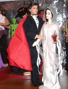 a couple dressed up as bride and groom with red cape on their head standing next to each other