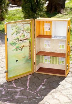 a doll house in a cardboard box with the door open to show it's interior