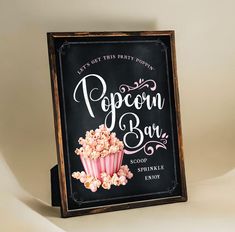 a sign advertising popcorn bar with pink cupcakes