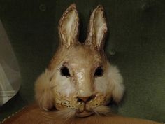 a rabbit mask sitting on top of a green chair