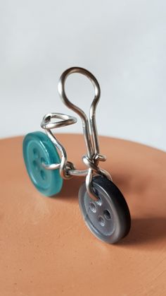 a metal hook with a button attached to it