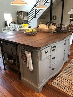 a large kitchen island sitting in the middle of a living room next to a stair case