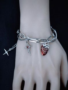 Elevate your gothic style with our handmade heart and cross charm silver bracelet. This exquisitely crafted piece features a striking combination of heart and cross charms, adding a touch of mystery and allure to your ensemble. The bracelet is meticulously handmade to ensure high quality and attention to detail.   Please note that this product includes only the bracelet. Gothic Silver Jewelry, Halloween Wings, Heart And Cross, Red Gothic, Gothic Bracelet, Edgy Jewelry, Gothic Vintage, Gothic Earrings, Gothic Accessories