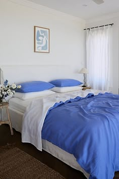 a bed with blue and white sheets in a bedroom