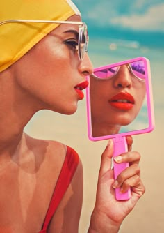 a woman with sunglasses on her head is looking into a mirror and holding a cell phone in front of her face