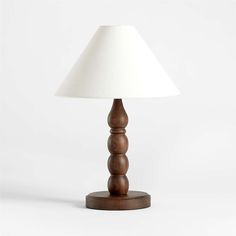 a wooden table lamp with a white shade on the top and bottom part of it