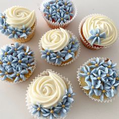 six cupcakes decorated with blue and white frosting