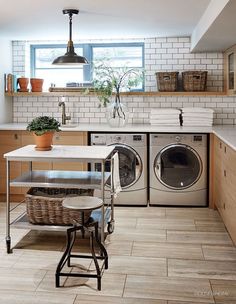 a washer and dryer sitting in a kitchen next to a counter with baskets on it