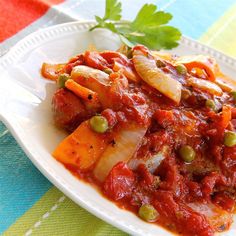 a white plate topped with meat and vegetables