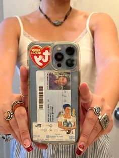 a woman holding up a cell phone case with an image of a man on it