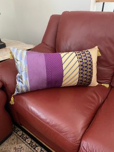 a brown leather couch with two pillows on it