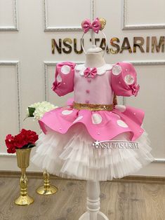 a pink and white dress on display in front of a sign that says nsu - lasarim