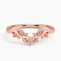 a rose gold ring with diamonds on the sides and leaves in the middle, set against a white background