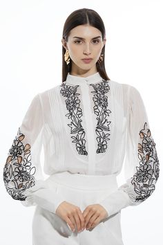 Get Dressed Up In Our Blouse, With A Flowing, Relaxed Silhouette, And Long, Balloon Sleeves, Paired With Contrasting Floral Detailing. This Piece Is Ultra Versatile, And Can Be Styled With Denim Jeans, Tailored Trousers, Or Shorts For Looks That Go From Office Days To Dinner Dates And Late Night Plans. Embroidery Bib Detail Woven Blouse Long Balloon Sleeves Contrasting Floral Embroidery High Neckline Comfortable, Relaxed Fit Button Front Detailing Embroidery On Blouse, Neckline Embroidery, Petite Work Outfits, Dress Work Outfit, Petite Business Casual, Bride Jumpsuit, Sequin Coats, Petite Wedding Guest Dresses, Jumpsuit For Wedding Guest