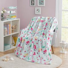 a child's bedroom with pink walls and white carpet, a blue blanket on the bed