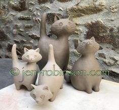 three ceramic cats standing next to each other