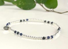 Introducing our beautiful Lapis bracelet, a piece designed to complement your style 24/7. Not only do we offer it in stunning Lapis, but you can also select from Moonstone, Jade, Black Onyx, or Pearl to create your perfect piece. Simply make your choice from the drop-down menu! My Personal Assurance to You: All our handcrafted pieces are born in our studio, nestled in a serene environment surrounded by nature's beauty, balance, and harmony. Our commitment to delivering a fast and friendly ordering experience ensures you can have this exquisite piece with you in no time. Enhance Your Gift: For a special touch, consider our $5 gift add-on. It includes a personalized card and a handwritten message, lovingly packaged in a gift bag, making your gift even more memorable. Discover the Qualities: Adjustable Sterling Silver Bracelet With Gemstone Beads For Gift, Minimalist Silver Bracelet With Gemstone Beads, Minimalist Silver Gemstone Beaded Bracelet, Adjustable Silver Stretch Bracelet With Gemstone, Silver Gemstone Stretch Bracelet Gift, Silver Hand-strung Lapis Lazuli Bracelet, Hand-strung Lapis Lazuli Bracelet For Meditation, Silver Lapis Lazuli Hand-strung Beaded Bracelets, 5 Gifts