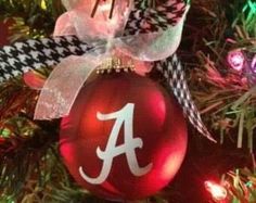 a christmas ornament with the letter a on it hanging from a christmas tree