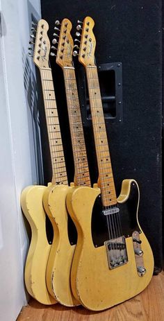 three guitars are sitting next to each other