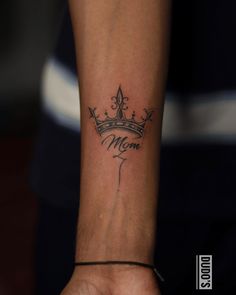 a woman's wrist tattoo with the word mom on it