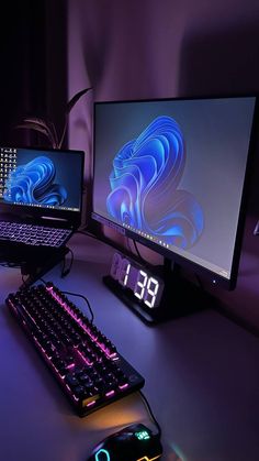 two computer monitors sitting on top of a desk next to a keyboard and monitor screen