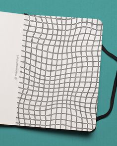 an open notebook with black and white lines on the cover, sitting on a blue surface